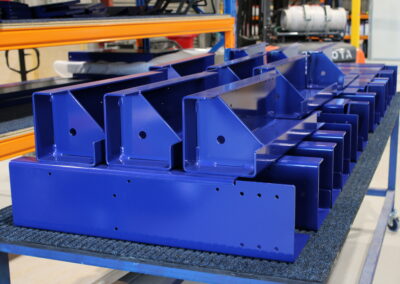 A neat stack of completed laser cut, cnc folded, and welded components, powder coated pommel blue.