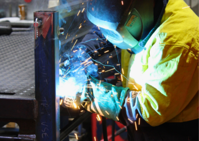 A Bromarc employee welding the headboard of an Ox Trailer